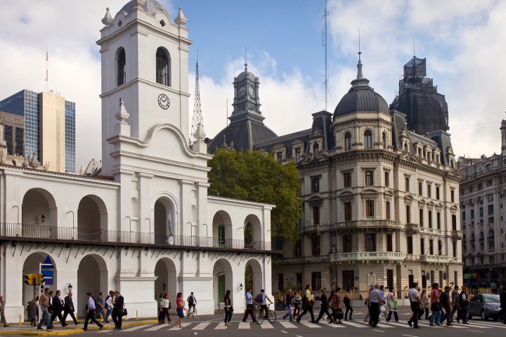 a group of people walking in front of a large building