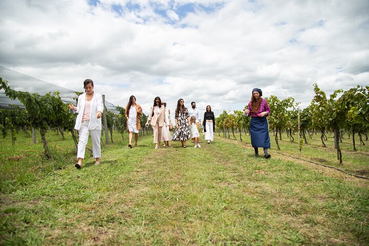 a group of people standing on top of a grass covered field